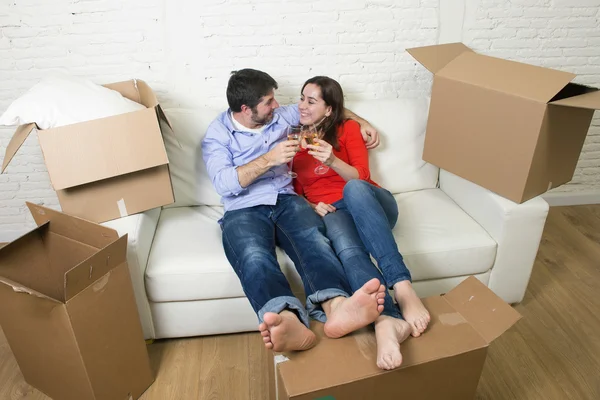 Happy American couple lying on couch together celebrating moving — стокове фото