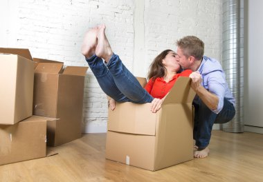 happy American couple unpacking moving in new house playing with