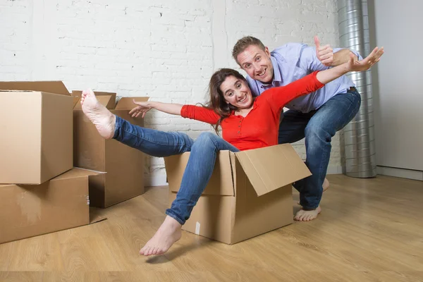 Happy American couple unpacking moving in new house playing with — Φωτογραφία Αρχείου