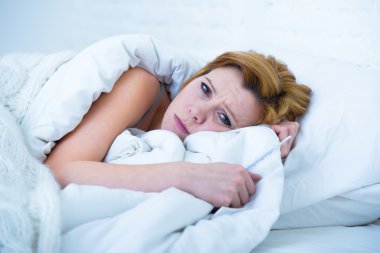 young woman  lying in bed sick unable to sleep suffering depression and nightmares insomnia sleeping disorder