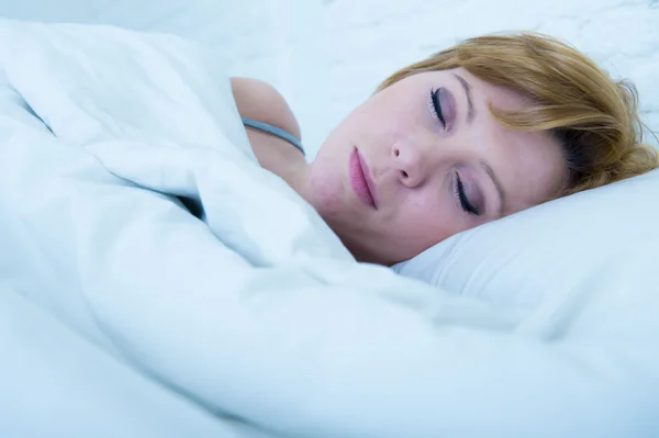 Faccia ravvicinata di giovane donna attraente con i capelli rossi dormire tranquillamente sdraiato a letto a casa a riposare e sognare — Foto Stock