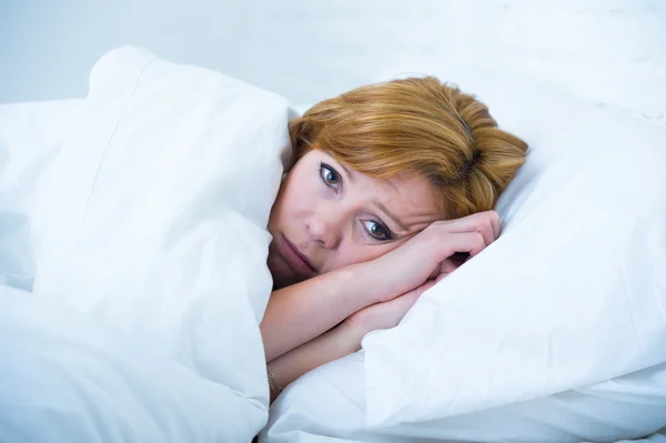 Mujer joven acostada en la cama enferma incapaz de dormir sufriendo depresión y pesadillas insomnio trastorno del sueño — Foto de Stock