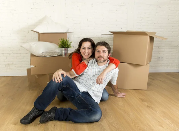 Jeune couple heureux assis sur le sol ensemble célébrer le déménagement dans une nouvelle maison ou appartement — Photo