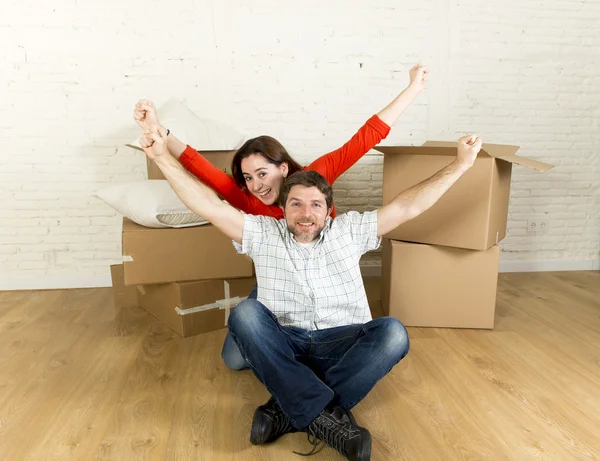 Young happy couple sitting on floor together celebrating moving in new flat house or apartment — Stock Photo, Image