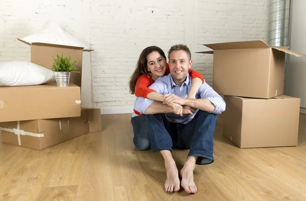 坐在地板一起庆祝搬进新平的房子或公寓的年轻快乐夫妇 — 图库照片