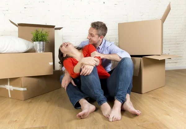 Lyckliga paret sitter på golvet firar inflyttning ny platt hus eller lägenhet — Stockfoto