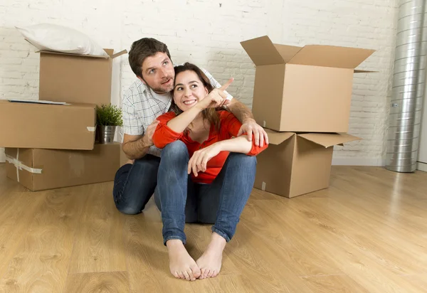 Couple heureux assis sur le sol pour célébrer le déménagement dans une nouvelle maison ou un appartement — Photo