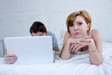 çekici kadın duygu üzgün tatminsiz ve hayal kırıklığı içinde yatak ile eşi onu görmezden bilgisayar dizüstü erkek çalışmaları sırasında