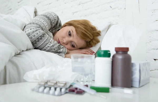 Sick woman feeling bad ill lying on bed suffering headache winter cold and flu virus having medicines — Stock Photo, Image