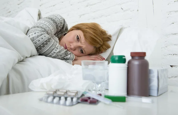 Kranke Frau, die sich schlecht fühlt, liegt krank im Bett und leidet unter Kopfschmerzen, Winterkälte und Grippeviren mit Medikamenten — Stockfoto