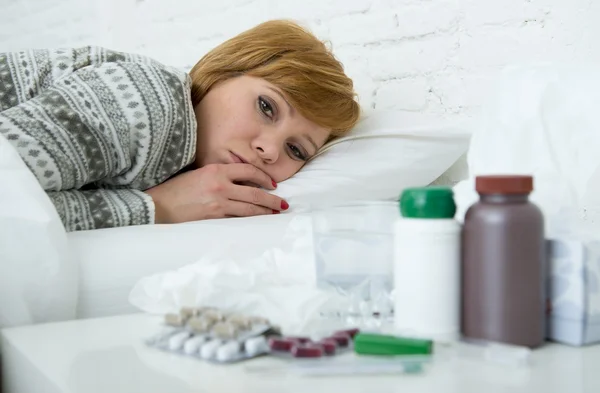 Kranke Frau, die sich schlecht fühlt, liegt krank im Bett und leidet unter Kopfschmerzen, Winterkälte und Grippeviren mit Medikamenten — Stockfoto