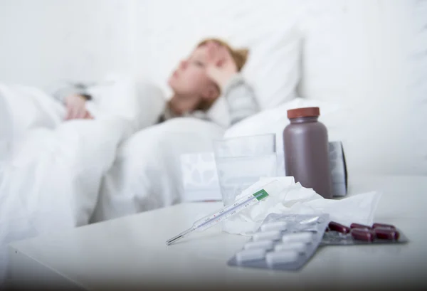 Kranke Frau, die sich schlecht fühlt, liegt krank im Bett und leidet unter Kopfschmerzen, Winterkälte und Grippeviren mit Medikamenten — Stockfoto