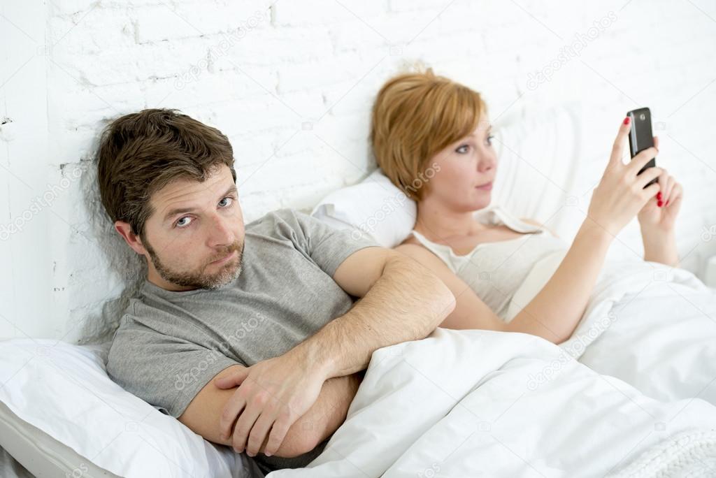 couple in bed husband frustrated upset and unsatisfied while his internet couple in bed husband frustrated upset unsatisfied while wife using mobile phone wife is using mobile phone