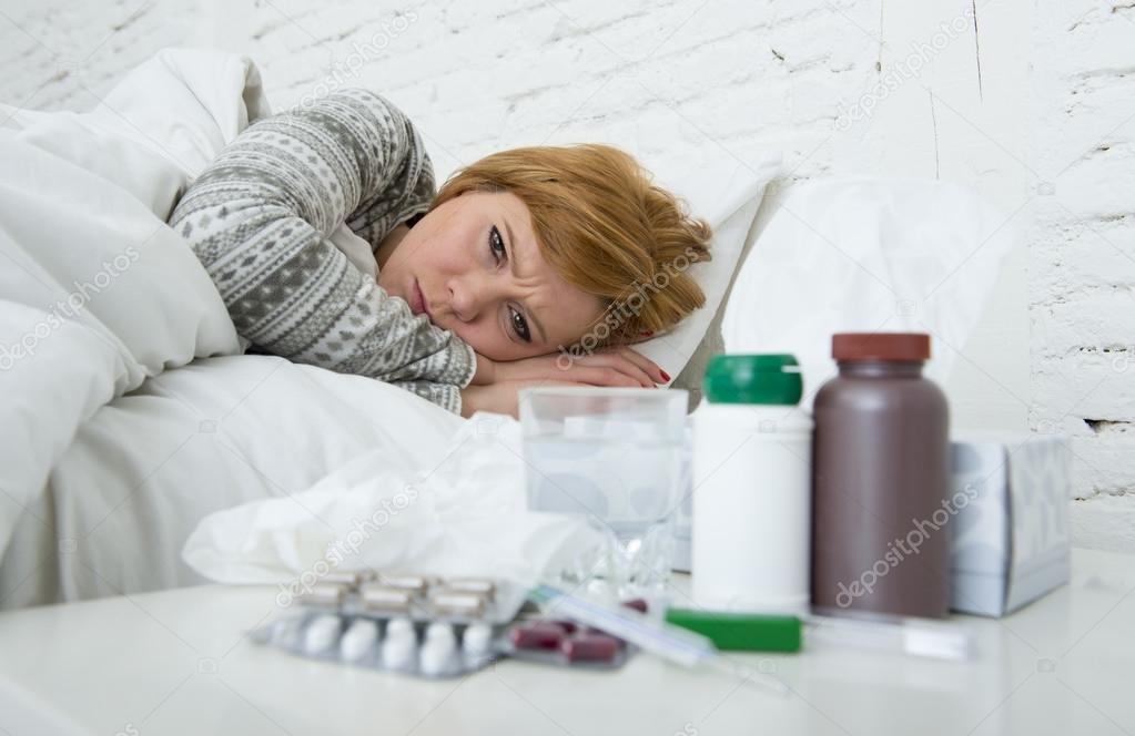  sick woman feeling bad ill lying on bed suffering headache winter cold and flu virus having medicines