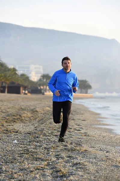 Jovem homem esporte correndo em exercício de fitness na praia ao longo do mar de manhã cedo — Fotografia de Stock