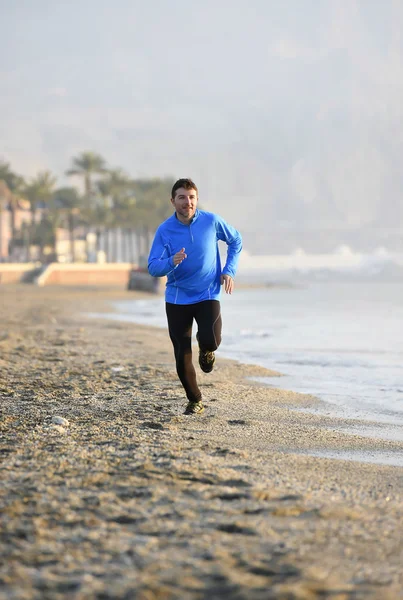 Junger Sportler läuft frühmorgens im Fitnesstraining am Strand am Meer entlang — Stockfoto