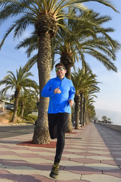 Sportler läuft beim morgendlichen Joggen am Strandpalmenboulevard entlang — Stockfoto