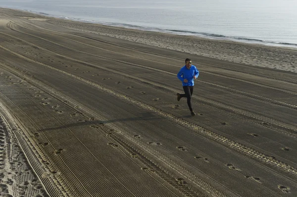 Jovem homem do esporte correndo sozinho na praia do deserto ao longo do treino de treinamento costa do mar — Fotografia de Stock