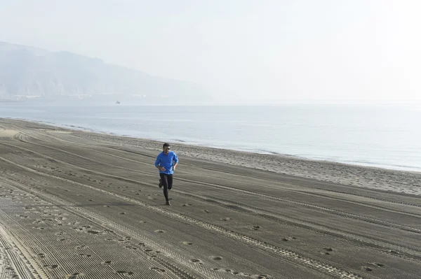 Olahraga muda berjalan sendirian di pantai gurun sepanjang latihan pantai laut — Stok Foto