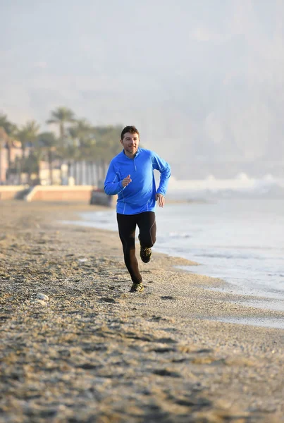 Jovem homem esporte correndo em exercício de fitness na praia ao longo do mar de manhã cedo — Fotografia de Stock