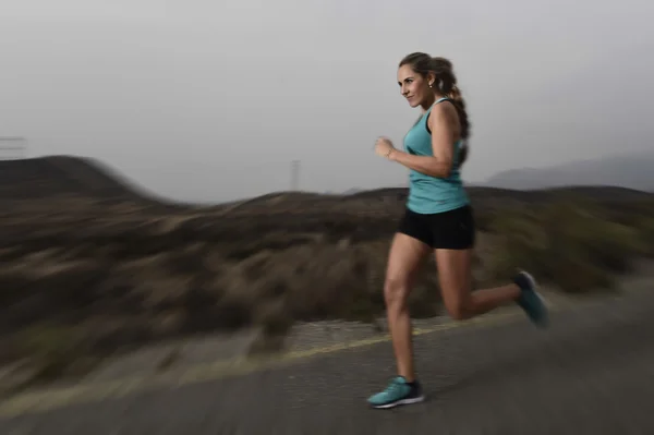 Wanita muda olahraga fit berlari di luar ruangan di jalan aspal dalam latihan kebugaran gunung — Stok Foto