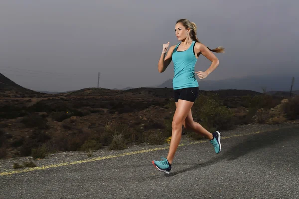 Wanita muda olahraga fit berlari di luar ruangan di jalan aspal dalam latihan kebugaran gunung — Stok Foto