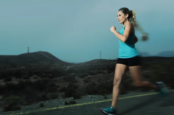 Mujer deportiva joven en forma corriendo al aire libre en el camino de asfalto en el entrenamiento de fitness de montaña — Foto de Stock