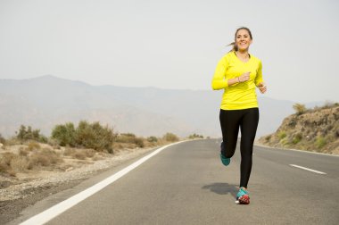 asfalt yol çöl Dağ manzara arka plan ile çalışan genç çekici spor kadın