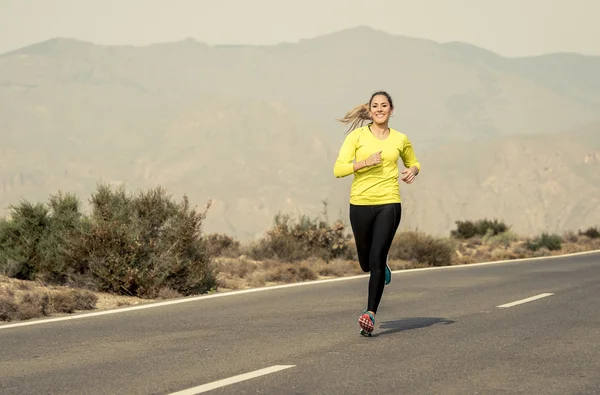 Joven atractivo deporte mujer corriendo en desierto montaña asfalto carretera — Foto de Stock