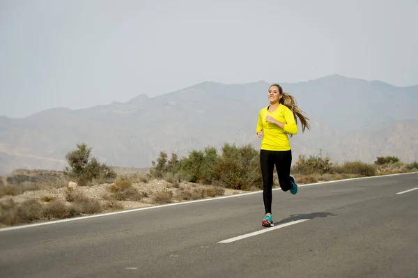 Joven atractivo deporte mujer corriendo en desierto montaña asfalto carretera — Foto de Stock