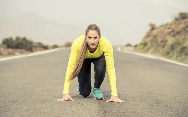 Vonzó szőke nő készen áll elindítani gyakorlati képzés futóverseny kezdődő aszfalt út hegyi táj sport — Stock Fotó