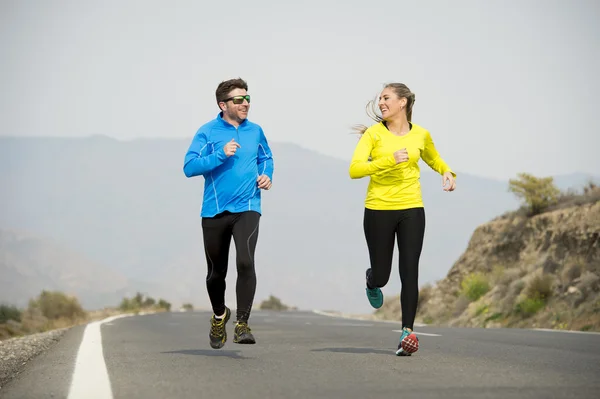 Vonzó sport pár férfi és nő fut össze aszfalt út hegyi táj — Stock Fotó