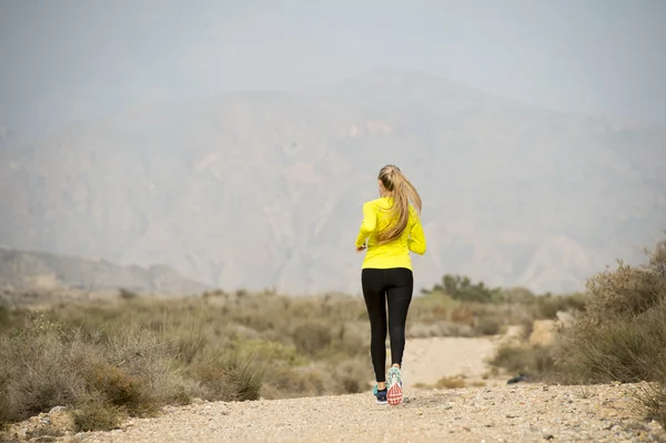 Back view sport runner girl training on earth trail dirty road desert mountain landscape — Φωτογραφία Αρχείου