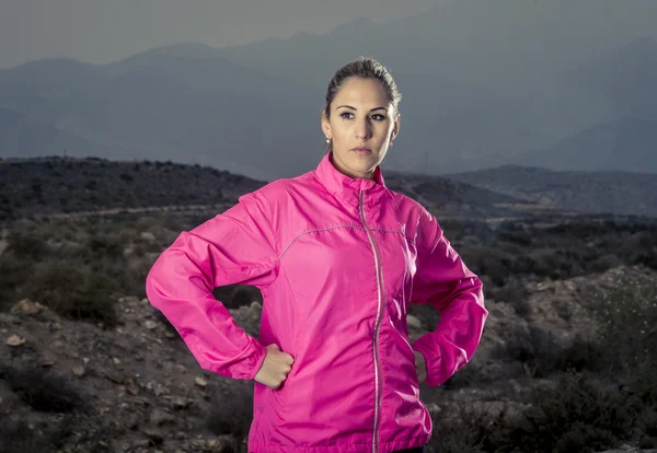 Wanita muda olahraga menarik dalam menjalankan jaket berpose dengan sikap menantang dingin — Stok Foto