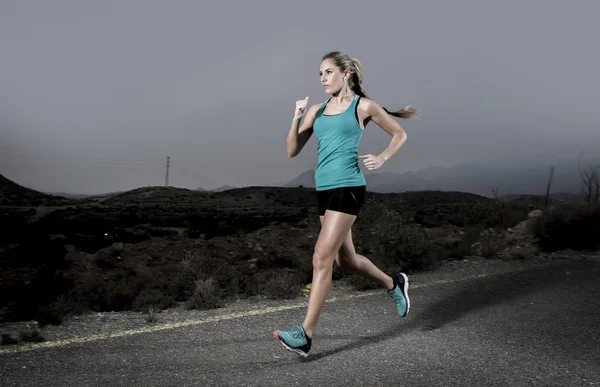 Mujer deportiva joven en forma corriendo al aire libre en el camino de asfalto en el entrenamiento de fitness de montaña — Foto de Stock