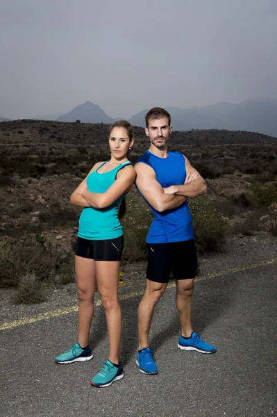 Junges Sportpaar posiert Schulter an Schulter und sieht cool und trotzig aus — Stockfoto