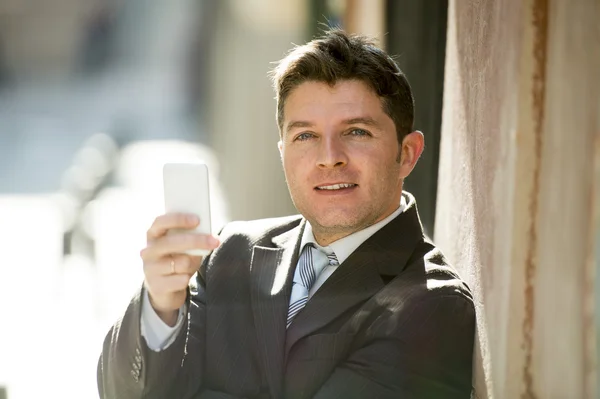 Занятой бизнесмен в костюме и галстуке с помощью мобильного телефона отправки сообщений или консультирования в Интернете — стоковое фото