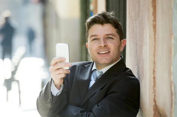 Zaneprázdněný podnikatel v obleku a kravatě, pomocí mobilního telefonu, odesílání zpráv nebo konzultační internetové — Stock fotografie