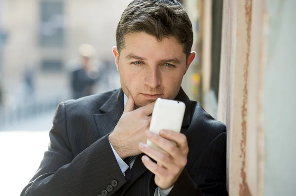 Hombre de negocios ocupado en traje y corbata usando el teléfono móvil que envía el mensaje o que consulta el Internet — Foto de Stock