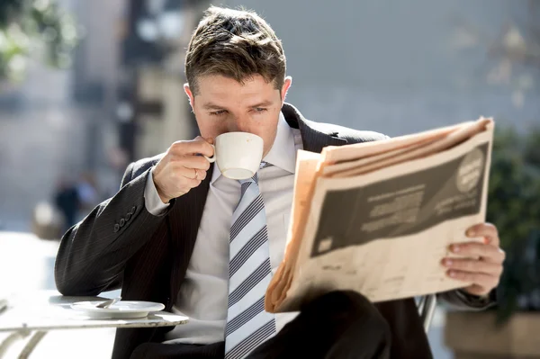 Hombre de negocios sentado al aire libre para el desayuno pausa mañana leyendo noticias en el periódico tomando café —  Fotos de Stock