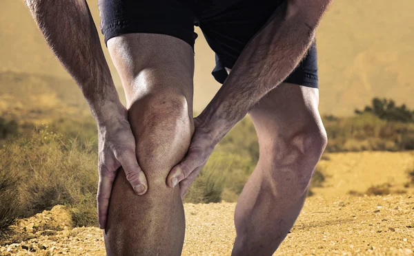 実行中の筋肉の損傷に苦しんでいる痛みで膝を押し運動脚を持つ若いスポーツ男 — ストック写真