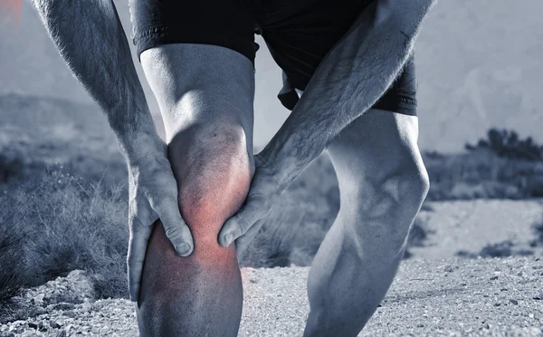 Jeune homme de sport avec des jambes athlétiques tenant genou dans la douleur souffrant de blessures musculaires courir — Photo