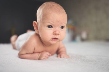 Sevimli, duygusal, komik, yeni doğmuş çocuk yatakta yatıyor. Bebek yüz ifadeleri. Bebek eşyaları paketleme şablonu. Sağlıklı çocuk, hastane kavramı ve mutlu annelik. Bebek, bebek. Çocuk odası..