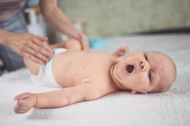 Annem bebek bezi değiştiriyor. Sevimli, duygusal, komik, yeni doğmuş bebek bebek beşikte yatıyor. Bebek eşyaları paketleme şablonu. Sağlıklı çocuk, hastane kavramı ve mutlu annelik. Bebek, bebek. Çocuk odası..