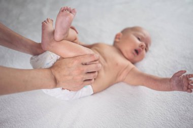 Annem bebek beziyle bebek için egzersiz yapıyor. Beşikteki sevimli, duygusal, komik, yeni doğmuş çocuk. Bebek eşyaları paketleme şablonu. Sağlıklı çocuk, hastane kavramı ve mutlu annelik. Bebek, bebek. Çocuk odası..