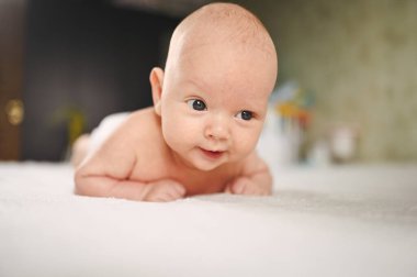 Sevimli, duygusal, komik, yeni doğmuş çocuk yatakta yatıyor. Bebek yüz ifadeleri. Bebek eşyaları paketleme şablonu. Sağlıklı çocuk, hastane kavramı ve mutlu annelik. Bebek, bebek. Çocuk odası..