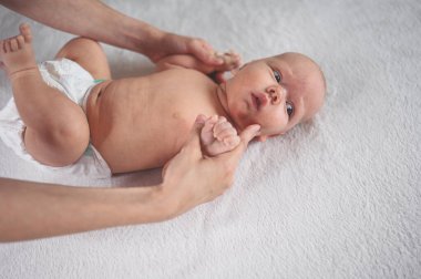 Annem bebek beziyle bebek için egzersiz yapıyor. Beşikteki sevimli, duygusal, komik, yeni doğmuş çocuk. Bebek eşyaları paketleme şablonu. Sağlıklı çocuk, hastane kavramı ve mutlu annelik. Bebek, bebek. Çocuk odası..