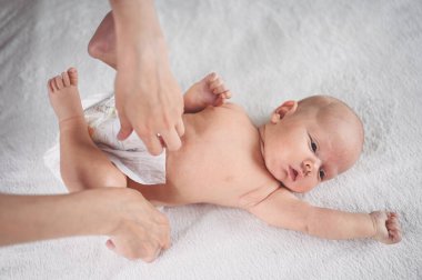 Annem bebek bezi değiştiriyor. Sevimli, duygusal, komik, yeni doğmuş bebek bebek beşikte yatıyor. Bebek eşyaları paketleme şablonu. Sağlıklı çocuk, hastane kavramı ve mutlu annelik. Bebek, bebek. Çocuk odası..