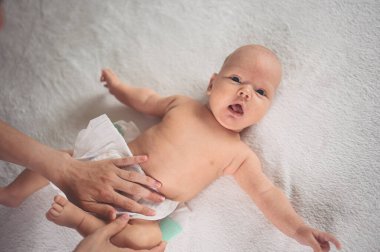 Annem bebek bezi değiştiriyor. Sevimli, duygusal, komik, yeni doğmuş bebek bebek beşikte yatıyor. Bebek eşyaları paketleme şablonu. Sağlıklı çocuk, hastane kavramı ve mutlu annelik. Bebek, bebek. Çocuk odası..