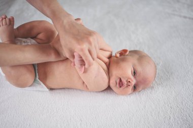 Annem bebek beziyle bebek için egzersiz yapıyor. Beşikteki sevimli, duygusal, komik, yeni doğmuş çocuk. Bebek eşyaları paketleme şablonu. Sağlıklı çocuk, hastane kavramı ve mutlu annelik. Bebek, bebek. Çocuk odası..